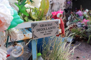 El Degolladito, Tinogasta, Catamarca, Arjantin 'deki boş plastik şişeler, haçlar ve diğer hatıra eşyaları. Dünyayla bu popüler ve putperest azizlerin tapınağı arasında gözle görülür bir bağlantı.
