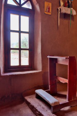 Ahşap bir dizlik ve kerpiç çerçeveli pencere, Adobe Yolu 'nun bir parçası olan Andacollo, Fiambala Tespihi' nin Hanımı Kilisesi 'nin mahrem özünü yakalar.