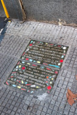 Buenos Aires, Arjantin 'deki Adli Tıp Birliğinin önündeki kaldırımda bir plaket. İnsanlığa ve sivil diktatörlüğe karşı işlenen suçları hatırlıyor.