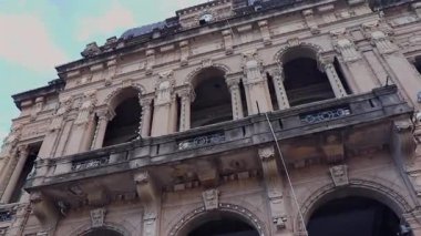 Balkondan, Tucuman Hükümet Binası 'nın yukarı bakan görüntüsü, önde gelen saatini, kubbesini ve Arjantin bayrağını gözler önüne seriyor..