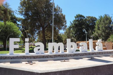 Fiambala, Catamarca 'nın merkez meydanının sakin manzarası. Şehir tabelası ve ağaçlar berrak bir gökyüzünün altında yıkanıyor.