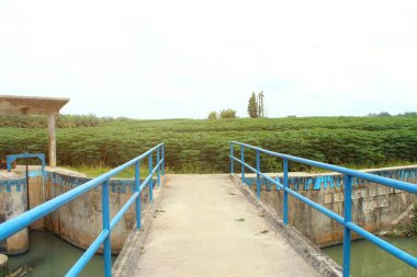 Endonezya 'daki nehirlerden birini geçen demir köprü. Mavi demir çitli nehir köprüsü
