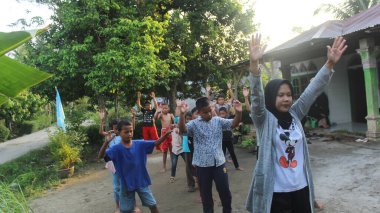 Simalungun Endonezya, 14 Ocak 2024 - bir grup insan jimnastik hocasıyla el kaldırıyor, bir genç kız, ardından da çocuklar.