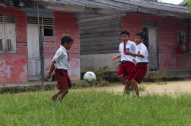 Simalungun Endonezya, 16 Ocak 2024 - Endonezyalı ilkokul öğrencileri okul bahçesinde mutlu bir şekilde futbol oynuyorlar