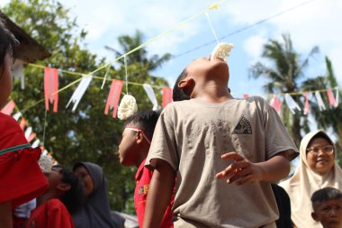 Batu Bara, Endonezya, 18 Ağustos 2024 - Endonezya Bağımsızlık Günü kutlamalarında çocuk krakerleri yeme yarışması