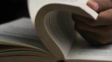 Bilinmeyen bir adamın elini kapat ve bir kitabın sayfalarını çevir.