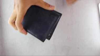 Bir adam boş bir cüzdan gösteriyor. Kötü bir işten ve az maaştan kaynaklanan mali sorunları olduğu için üzgün bir insan..