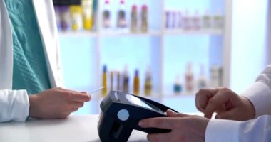 Yakın çekim müşteri eli kablosuz ödeme NFC teknolojisi yapmak için akıllı telefon kullanır. 4k 'lık kontaksız salgın hastalık konseptini kapatın.