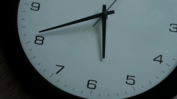 時間と分の手が時計回りに動くのを示す壁の時計の矢印を閉じる — ストック動画