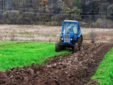 Sonbaharda traktörün yardımıyla tarla sürme makineleri.