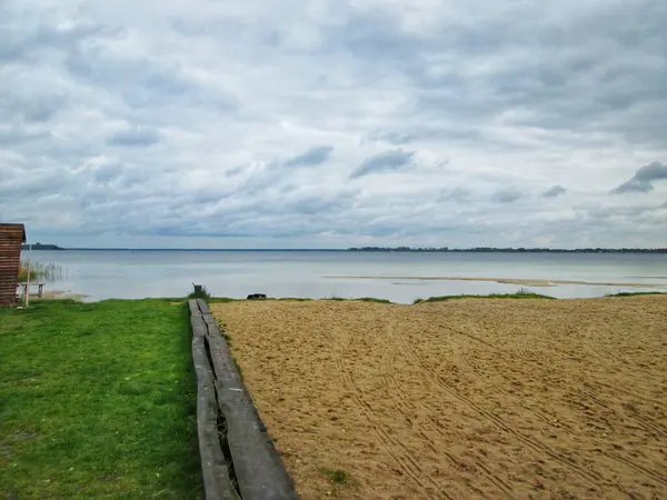 Bulutlu bir gökyüzünün altında sakin bir göl.