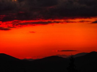 Renkli gökyüzü ile dağ sırtlarının üzerinde canlı günbatımı
