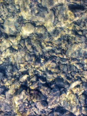 Temiz su, pürüzsüz nehir taşlarının üzerinden akıyor