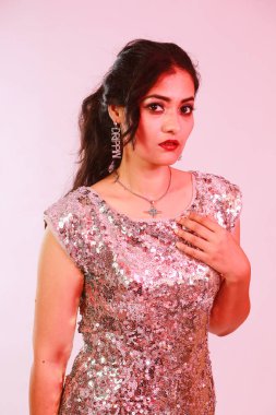 Çekici, şık, gümüş bluzlu ve kolyeli model, neon ışıklı stüdyoda poz veren küpeler.. 