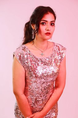 Çekici, şık, gümüş bluzlu ve kolyeli model, neon ışıklı stüdyoda poz veren küpeler.. 