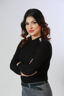 Beyaz arka planda uzun kollu siyah kazaklı bir kız.