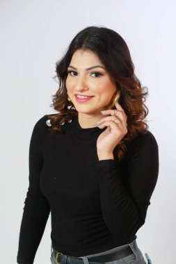 Beyaz arka planda uzun kollu siyah kazaklı bir kız.