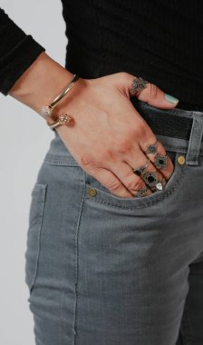 Fashionable trendy woman's hand going in her jeans front pocket