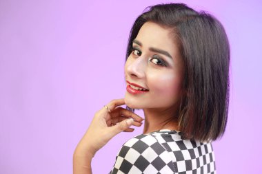 Portrait of young beautiful cute cheerful girl looking at camera with smile and style over pink background.