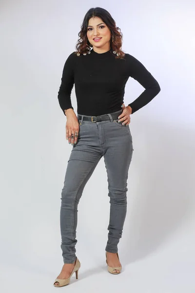 stock image Girl in a black sweatshirt with a long sleeve and grey jeans on a white background