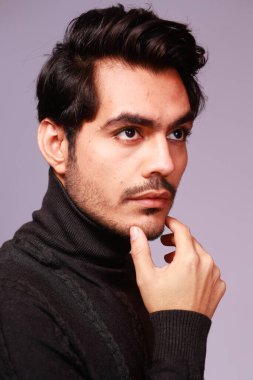 Portrait of interested thoughtful man touching his chin looking away