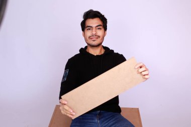 Young attractive asian male model, Holding an empty sign copy space and looking in Camera. Handsome man presenting your brand or offer