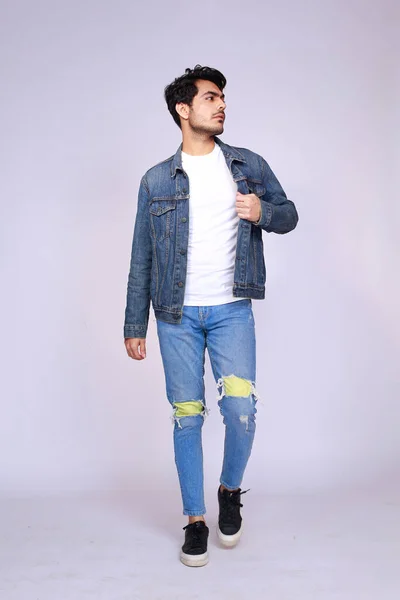 Young attractive asian male model, wearing denim jacket and pants, posing men's fashion and style on a white studio background