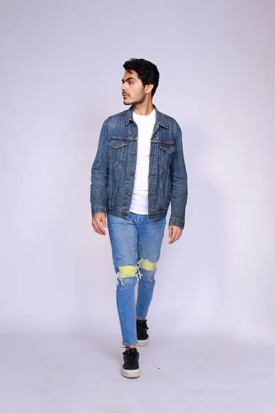 Young attractive asian male model, wearing denim jacket and pants, posing men's fashion and style on a white studio background