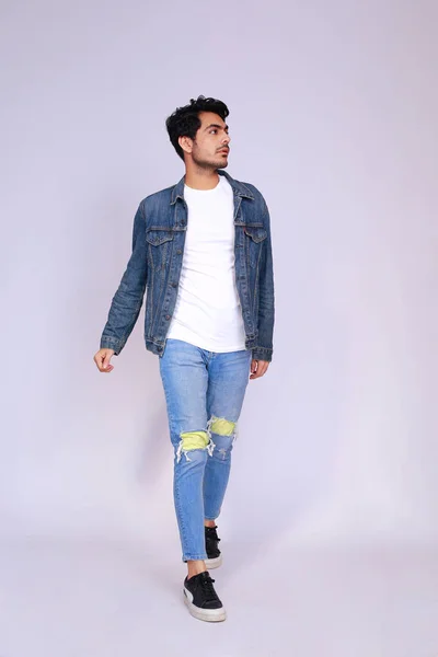 Young attractive asian male model, wearing denim jacket and pants, posing men's fashion and style on a white studio background