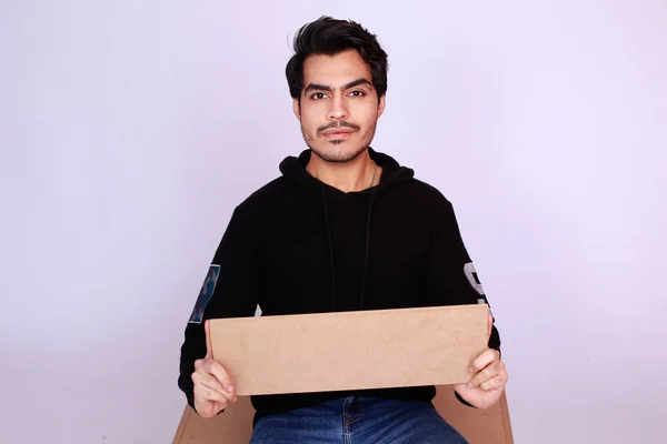 Young attractive asian male model, Holding an empty sign copy space and looking in Camera. Handsome man presenting your brand or offer