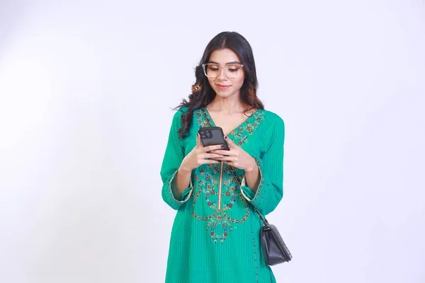 Photo of cute Happy brown girl with long hair woman casually dressed holding phone looking in phone. Isolated white colour background