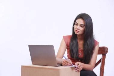 Young Businesswoman on a video conference using Computer. Stylish Beautiful Manager busy working and taking notes. Isolated on white background