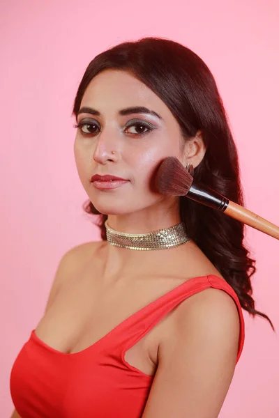 Blush being applied on beautiful woman face. Makeup brush on cheeks of beauty model girl and the Make up is in process, image represents a beauty shot