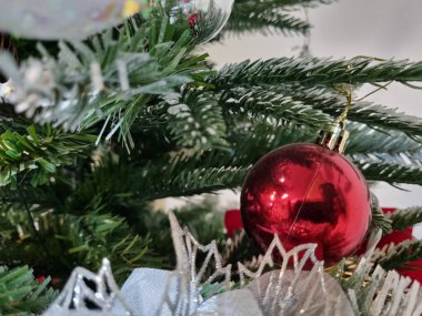 Üzerinde kırmızı yıldız süsleri olan bir noel ağacı.