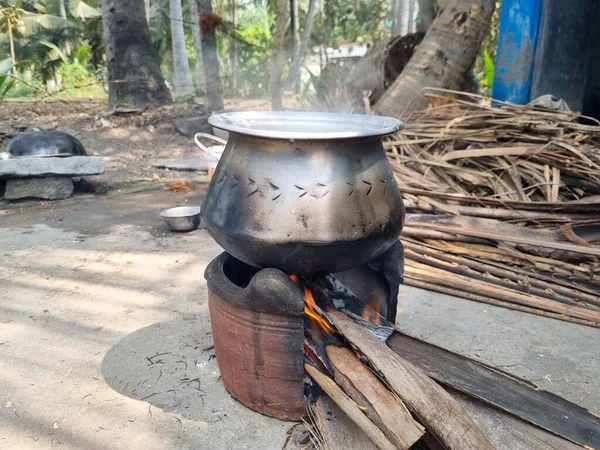 A pot on a fire with the word \