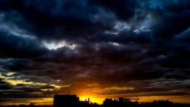 Batan güneşin turuncu ışığı Bangalore, Hindistan 'daki gökdelenleri ve yüksek binaları aydınlatıyor.