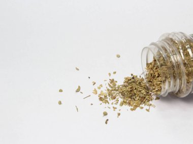 aromatic and fresh dried basil spilled on white background with free space for product