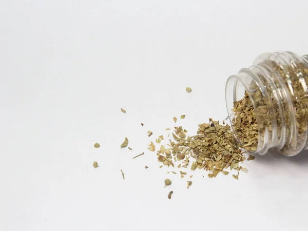 aromatic and fresh dried basil spilled on white background with free space for product