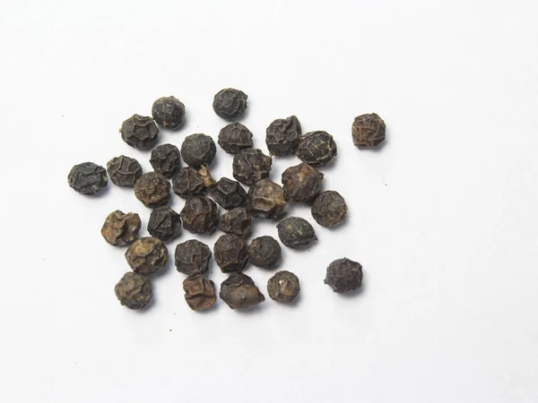 dried black pepper spice on white