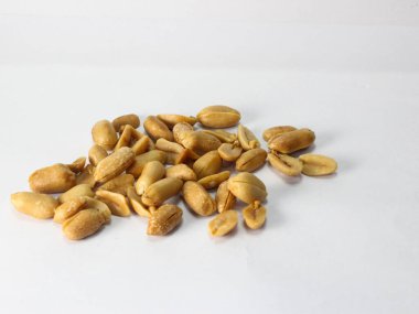 Beyaz arka planda soyulmuş çiğ fıstık yığını.