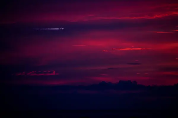 紫色の劇的な日没の上を飛ぶ飛行機のシルエット ポルトガル — ストック写真