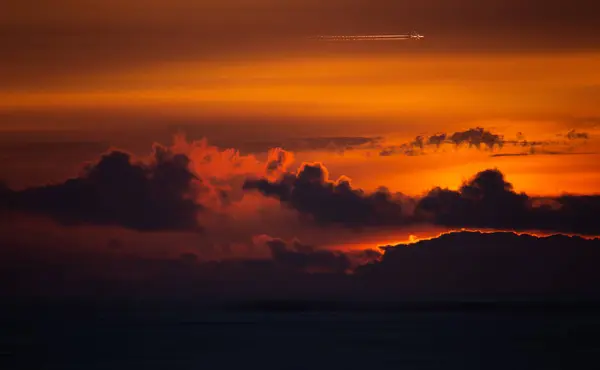 オレンジ色の劇的な日没の上を飛ぶ飛行機のシルエット ポルトガル — ストック写真