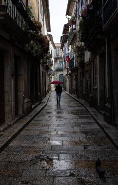 30 Ekim 2023, Guimares sokaklarında yürüyen bir cadde, UNESCO Dünya Mirası, ışık ve gölgeleri kovalayan, Guimares, Portekiz.