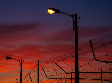 Soğuk kış günbatımında sokak lambası silueti, Merelim, Braga, Portekiz.