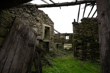 Portekiz 'in kuzeyindeki küçük bir köyde, çatısı olmayan, içeriden bakan, hava ve iklimle harap olmuş antik taş bir ev..