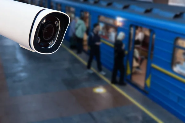 CCTV, security camera system operating with people waiting subway at train station, surveillance security and safety technology concept