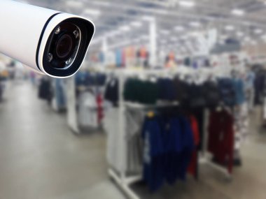 Arka planda güvenlik kamerası mağazası var..