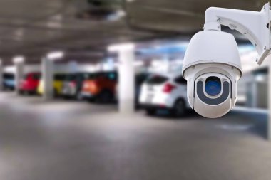 CCTV security camera on blur car parking. Copy space