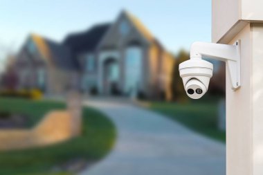 Arka planda güvenlik kamerası ve özel ev var.