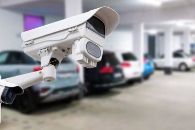 CCTV security camera on blur car parking. Copy space